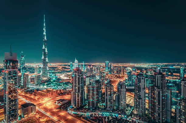 Fantastic nighttime skyline of a big city with illuminated skyscrapers Fantastic nighttime Dubai skyline with illuminated skyscrapers. Rooftop perspective of downtown Dubai, UAE. dubai stock pictures, royalty-free photos & images
