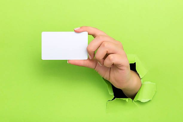 istock Female hand reaching through torn green paper sheet 598250348
