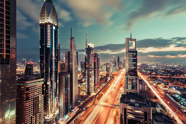 Scenic downtown Dubai skyscrapers at night with illuminated road. Scenic Dubai downtown architecture in the evening. Aerial view of the Sheikh Zayed road with skyscrapers. Fantastic travel background. dubai street stock pictures, royalty-free photos & images