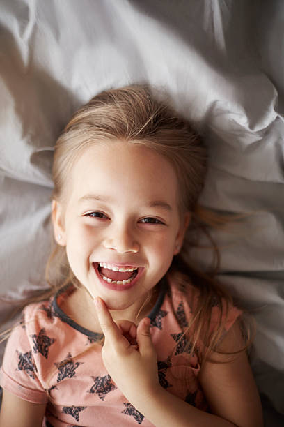 istock Girl laughing in her bed 598255880
