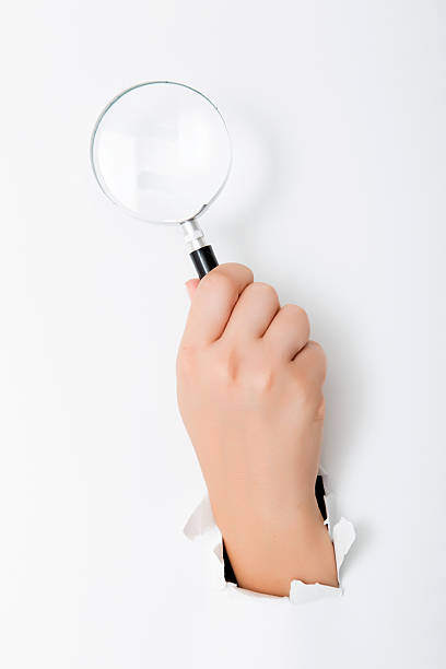 istock Large magnifying glass in hand isolated on white background 598258604