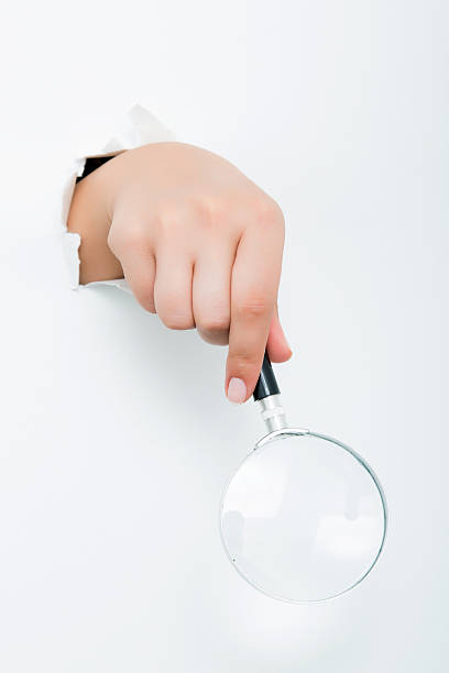 istock Large magnifying glass in hand isolated on white background 598258710