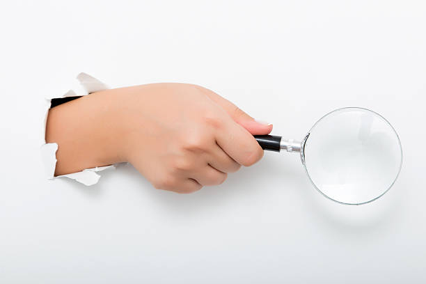 istock Large magnifying glass in hand isolated on white background 598258950