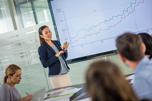 Businesswoman giving presentation in conference room.