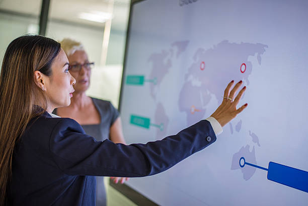 Business presentation Businesswoman explaining graph to his coworker in conference room. global business stock pictures, royalty-free photos & images