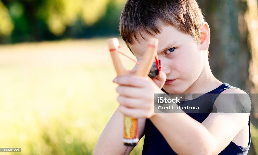 Niño pequeño jugando con tirachinas - Foto de stock de Niño libre de derechos