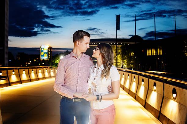 istock Young couple hugging on the bridge at night. 598522076