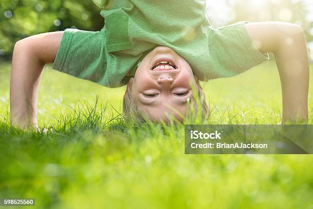 Young Boy Doing A Headstand On The Grass Stock Photo - Download Image Now - Child, Happiness, Playful