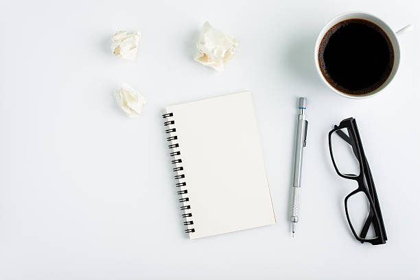 istock cop of coffee with notebook on white background 598525682