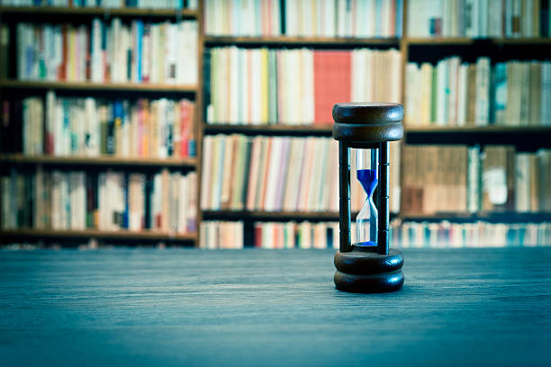 istock Hourglass against book shelf 598526034