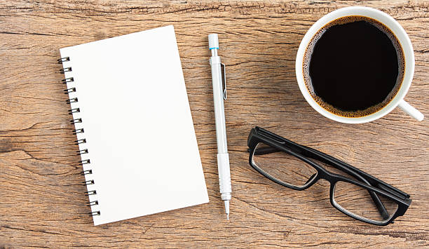 istock cop of coffee and notebook on wooden desk 598526666