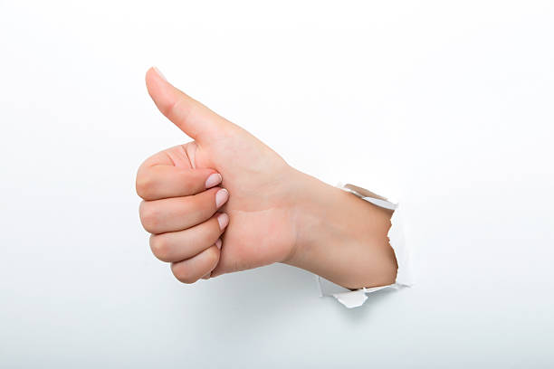 istock Thumbs up through the paper hole isolated on white background 598526962