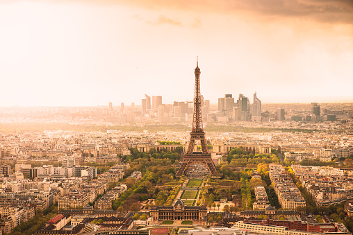 Paris cityscape with the Eiffel Tower, Champs de Mars, and La Defense at sunset.