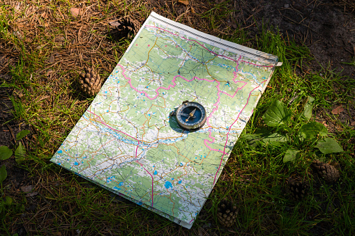 map and compass on a path in the woods