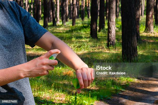 Girl In The Forest Uses The Spray Against Mosquitoes Stock Photo - Download Image Now