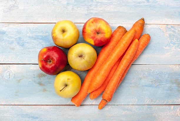 istock Apples and carrots on a blue wooden board 598529730