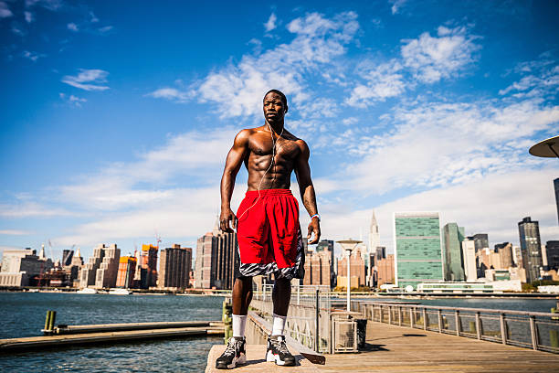 Healthy man exercising and running in early morning in Long Island City, in front of a beautiful New York City skyline.
