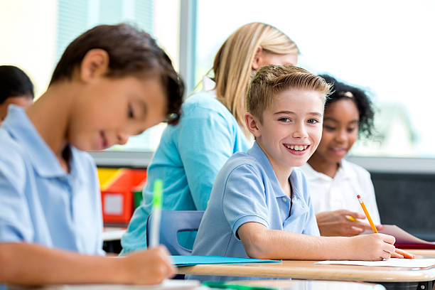 istock Smiling Caucasian boy sitting in classroom looking at camera 598529932