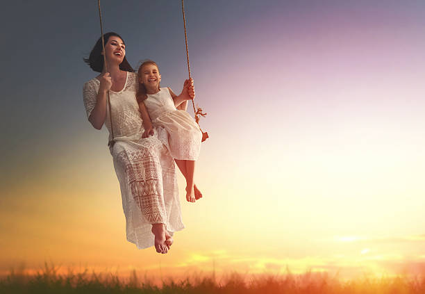 istock mother and  daughter swinging on swings 598530698