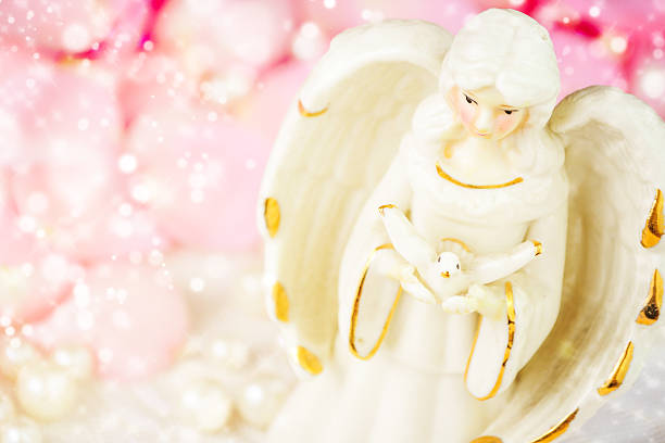 istock Angel statue on golden background 598531260