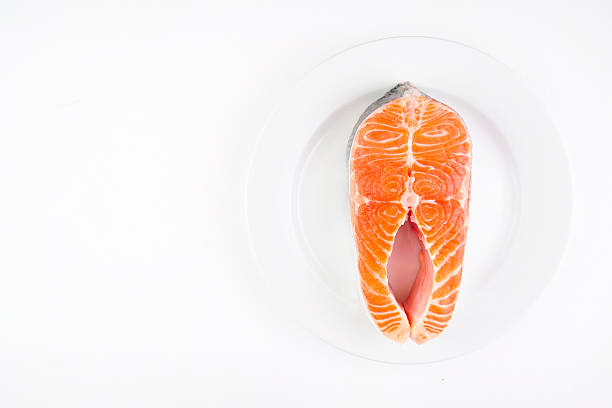 Raw fillet of fresh salmon fish on white plate