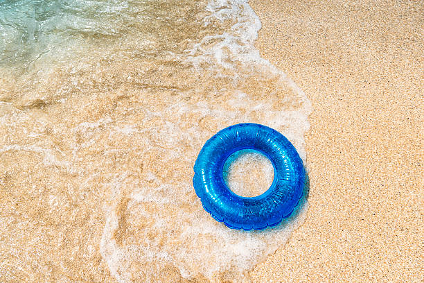 breaking wave and rubber ring on Pedn Vounder Beach, Cornwall. From above with room for copy.