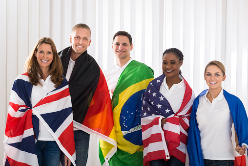 Group Of Happy Friends With Flags From Different Countries