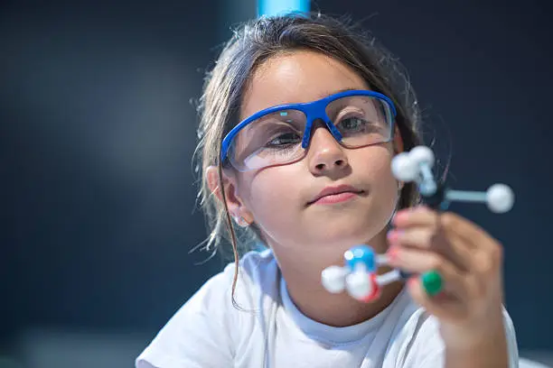 Young scientist looking at a molecular structure model.