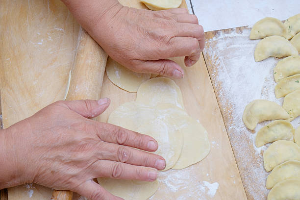 istock Dough being flattened on a wooden wooden board 598534756