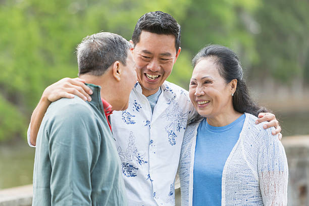 istock Asian man with senior parents in park talking 598536800