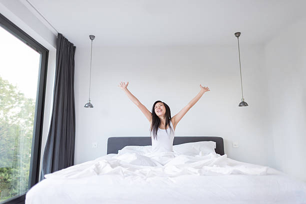 Asian woman yawning in bed