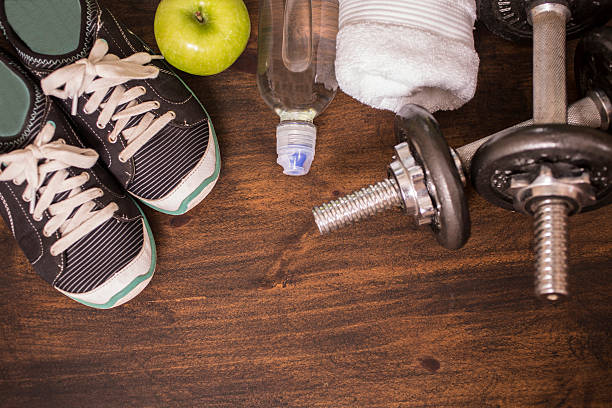 istock Fitness, exercise themed scene with weights, sneakers, apple. 598538884