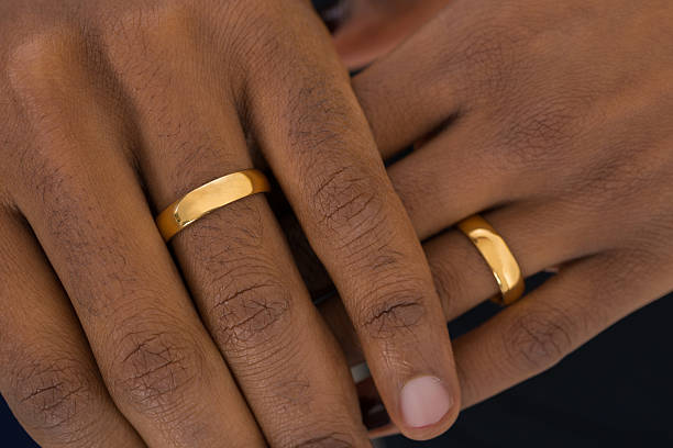 Hands Wearing Golden Rings Close-up Of African Hands Wearing Golden Rings 50th anniversary photos stock pictures, royalty-free photos & images