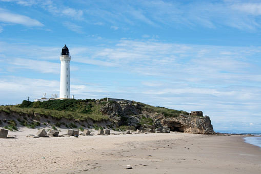 Coastal Scene with lighthouse, beach and sea caves