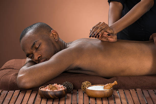 Man Getting Massage In Spa Young African Man Getting Massage In Spa massage therapist photos stock pictures, royalty-free photos & images