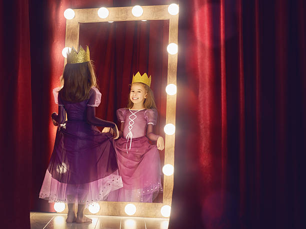 Cute little actress. Cute little actress. Child girl in Princess costume on the background of theatrical scenes and mirrors. theatre mirror stock pictures, royalty-free photos & images