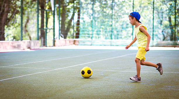 istock Boy with  football ball on stadium 598542506