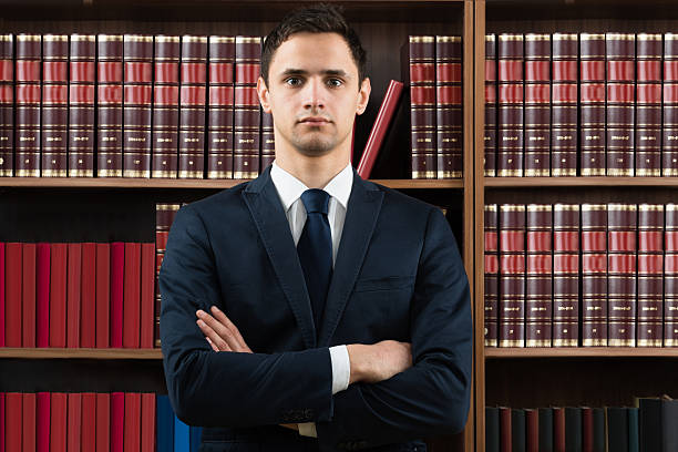 istock Confident Lawyer Standing Arms Crossed Against Bookshelf 598544876