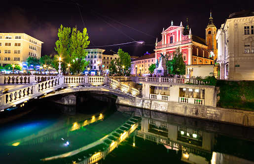 Slovenia Ljubljana Tromostovje Ljublianica river Church with bridge and boat at night