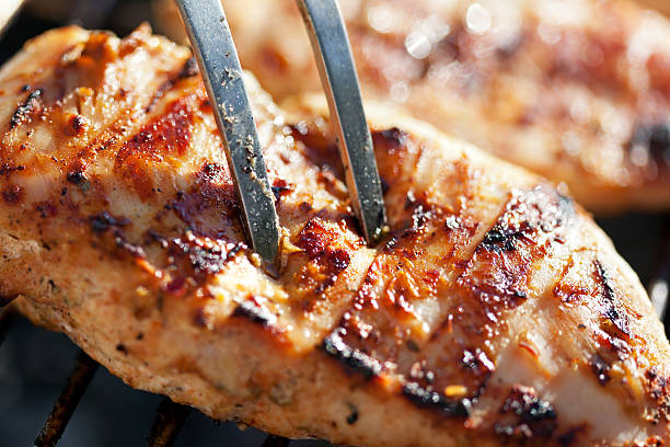 Grilled chicken breast on barbeque Grilled chicken breast on barbeque, cooking process. Macro shot, shallow depth grilled chicken breast stock pictures, royalty-free photos & images