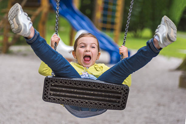 istock Cute Girl Swing on Playground Acting Silly 598547264