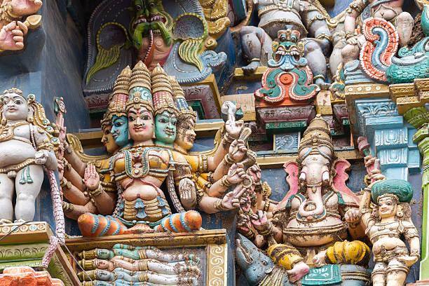 Madurai, India - October 19, 2013: Closeup of goddess Gayatri sitting on coffin with the four Vedas inside. Ganesha keeps her company. Facade of West Gopuram at Meenakshi Temple.