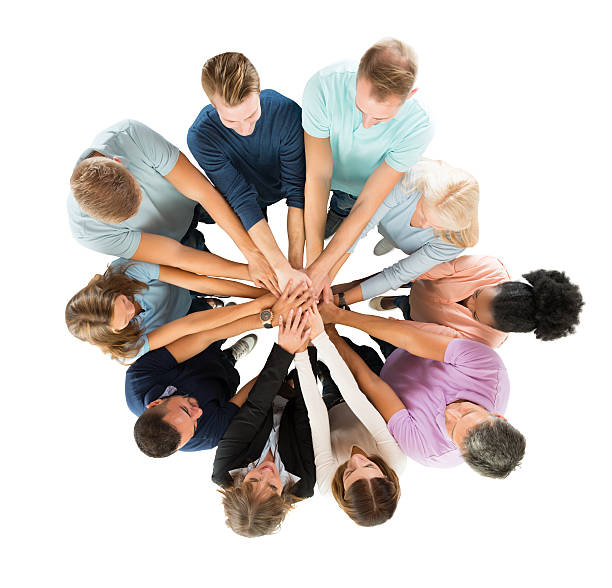 Creative Business People Stacking Hands In Huddle Directly above shot of people stacking hands while standing against white background stacked hands photos stock pictures, royalty-free photos & images