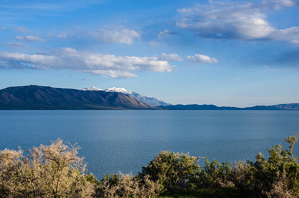 Utah Lake Looking east over Utah Lake, UT, USA on a warm clear day, the blue sky dotted with clouds. lake utah stock pictures, royalty-free photos & images