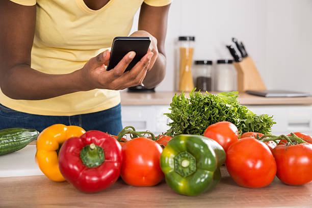 istock Close-up Of A Woman Using Mobile Phone In Kitchen 598551340