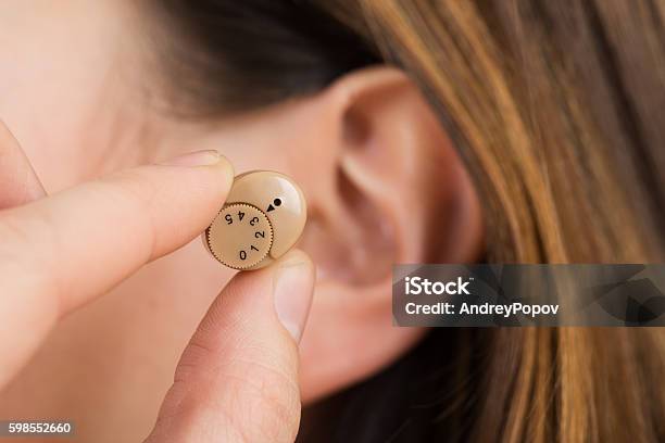 Woman Hands Putting Hearing Aid In Ear Stock Photo - Download Image Now - Hearing Aid, Small, Adult