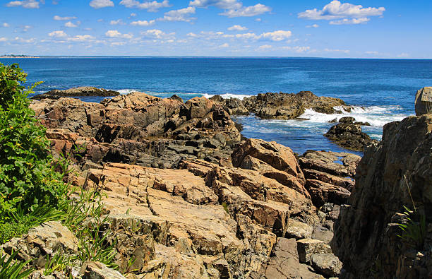 Landscape with Marginal Way in Ogunquit, Maine, New England, USA. Turquoise ocean waters, rocks, green bushes and vivid blue sky with clouds are in the image. Canon EF 24-105mm f/4 L IS lens. Polarizing filter.