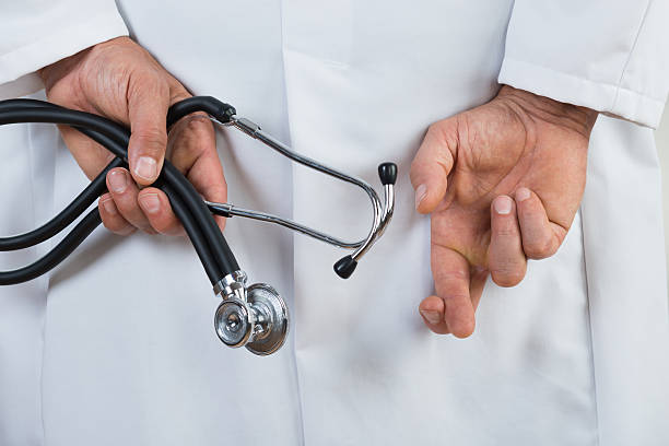 istock Male Doctor With Fingers Crossed 598553552