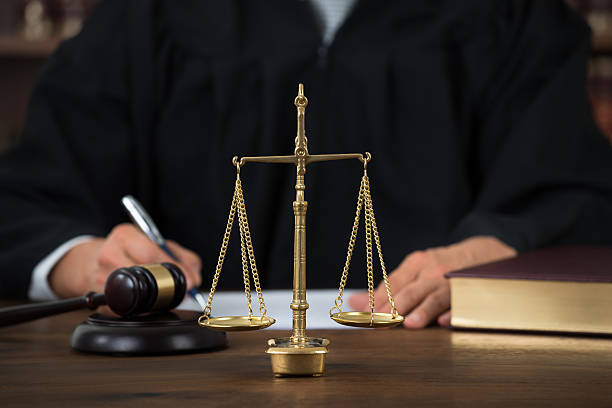 istock Law Scales On Table With Judge Writing In Background 598554012