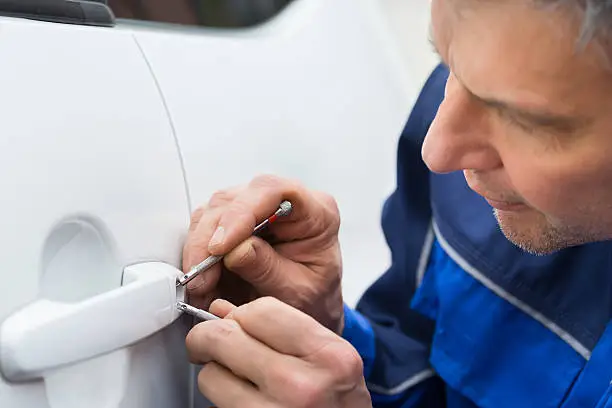 Close-up Of Person Hand Holding Lockpicker To Open Car Door